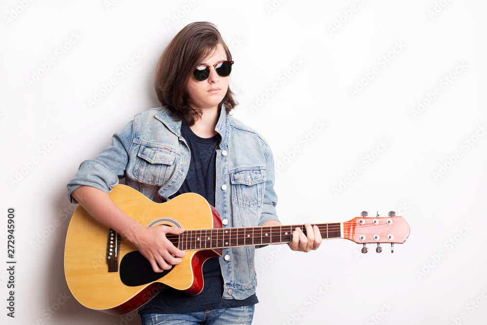 Portrait of a teenager with guitar in studio. Portrait of a teenager with guitar in studio.