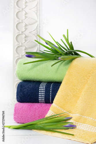 Towels in stack against the blured backdrop, stack of green, blue, yelloy and pink towels with flowers. photo