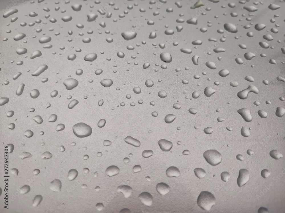 Rain water on a silver car skirt 