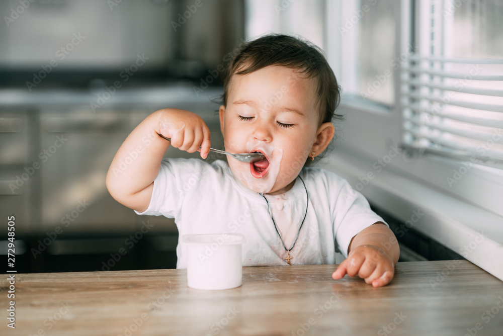 A little charming girl eats yogurt all smeared herself A little charming girl eats yogurt all smeared herself