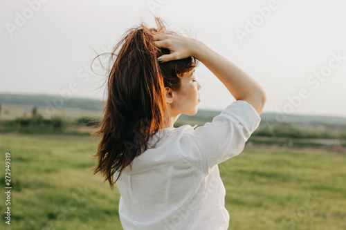 Close up portrait of beautiful carefree long hair girl in white clothes in field. Sensitivity to nature concept