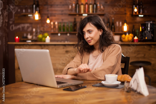 Portrait of smart beautiful woman using laptop for work in a coffee shop