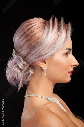 Side view portrait of beautiful woman with stylish coiffure on studio background