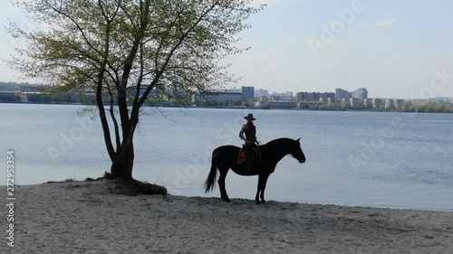 Western lady in old cowboy clothes is sitting on the horse, 4k