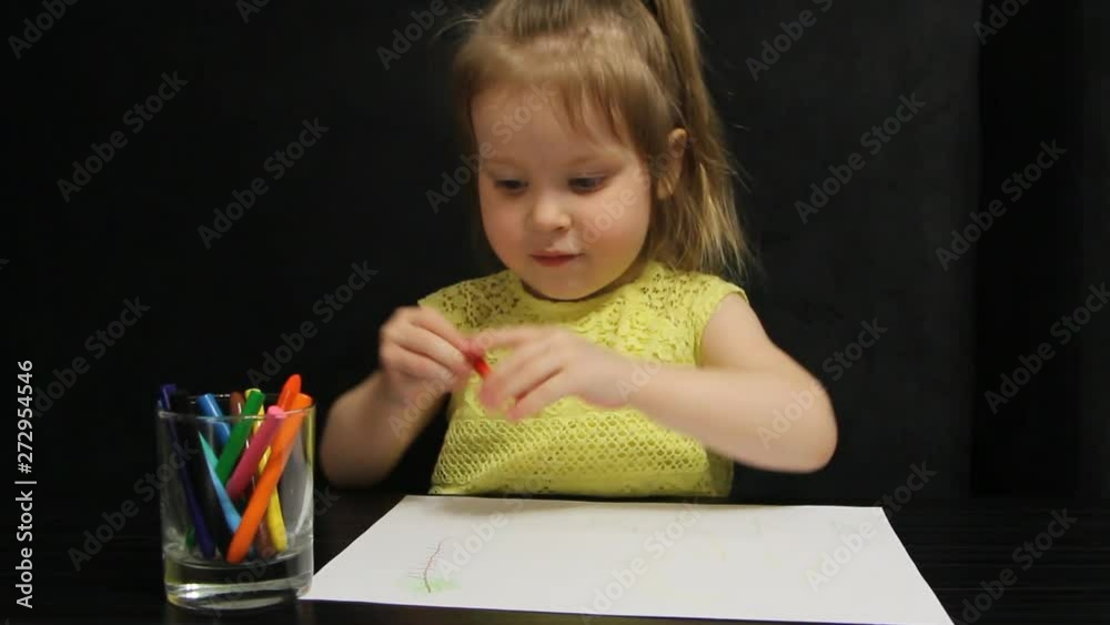 Little girl draws with red pencil on paper Little girl draws with red pencil on paper