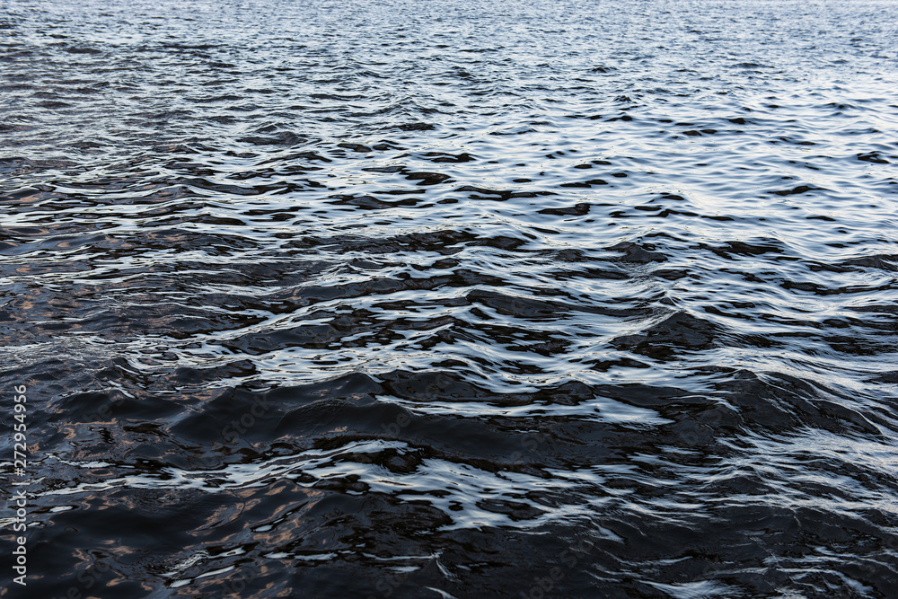 Obraz premium Dark water surface background with small waves and reflections. Dangerous deep river.