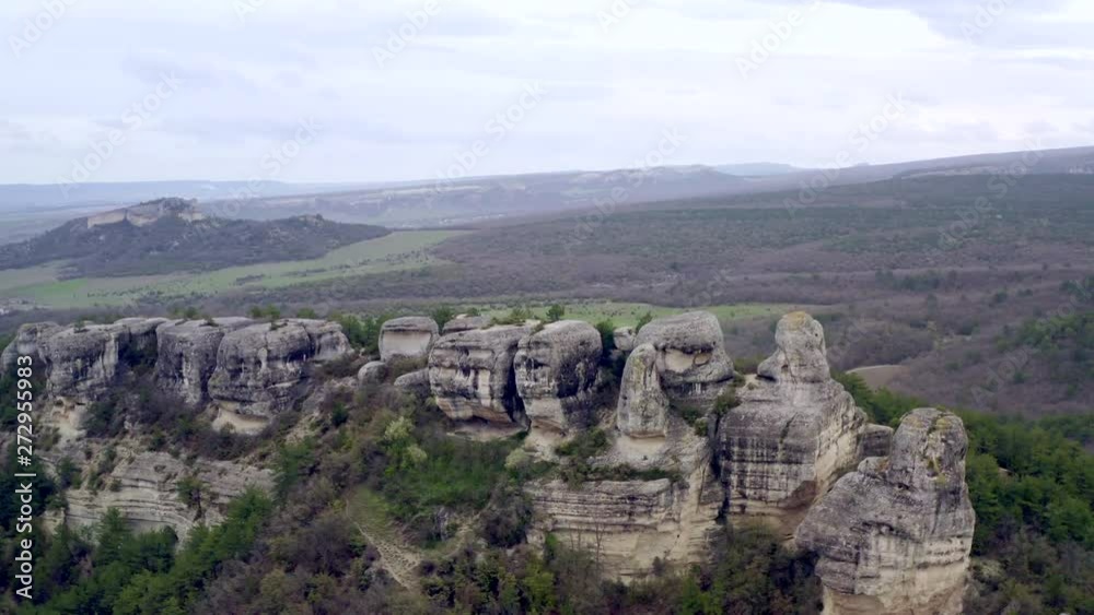 Panoramic view of the cave city in the rocks on cliff. Flying over a rocky plateau with houses carved in stone. Aerial shots. Archaeological monuments. Mountain landscape Panoramic view of the cave city in the rocks on cliff. Flying over a rocky plateau with houses carved in stone. Aerial shots. Archaeological monuments. Mountain landscape