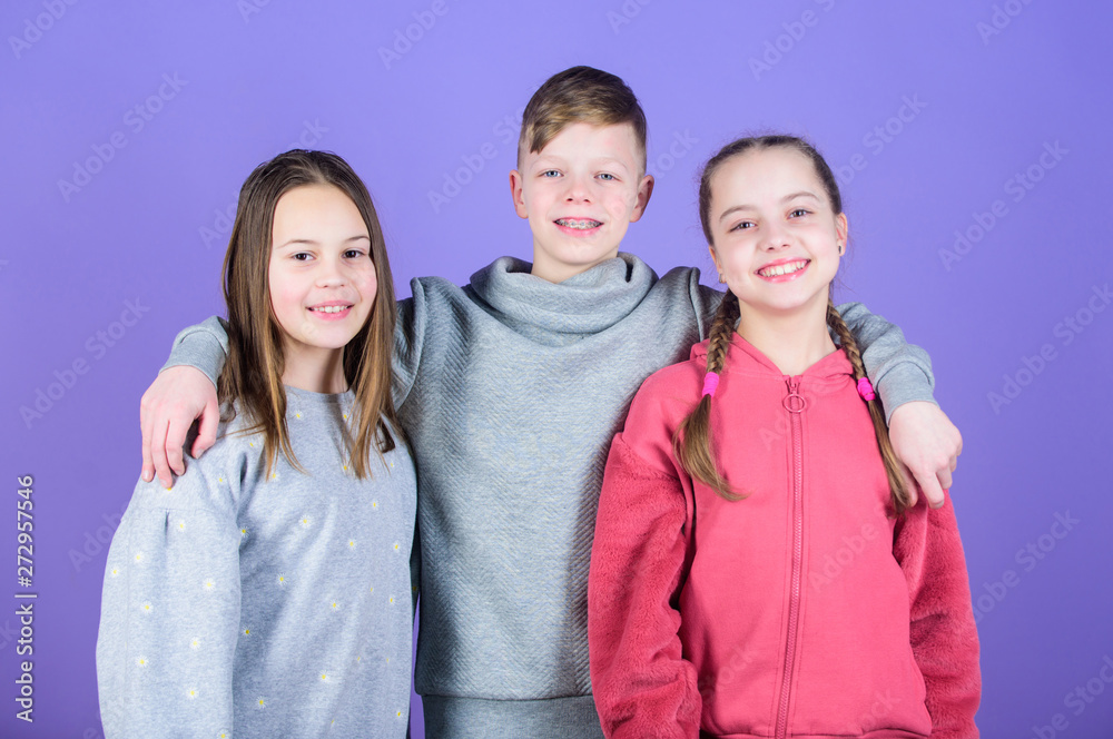 Children smiling faces on violet background. Friends hug. Childrens day. Cheerful youth. Relations and friendship. Happy to have such good friends. Teens friends. Girl and boy true friendship Children smiling faces on violet background. Friends hug. Childrens day. Cheerful youth. Relations and friendship. Happy to have such good friends. Teens friends. Girl and boy true friendship