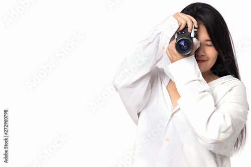 Woman photographer working  in  studio. Asian woman photography in action on white background. Girl  wearing white shirt holding vintage camera in hand free from copy space.