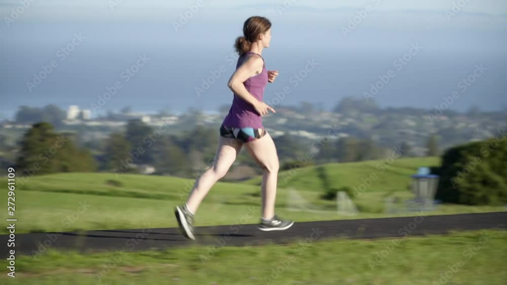 Young Woman Running on a Track at Sunset Young Woman Running on a Track at Sunset