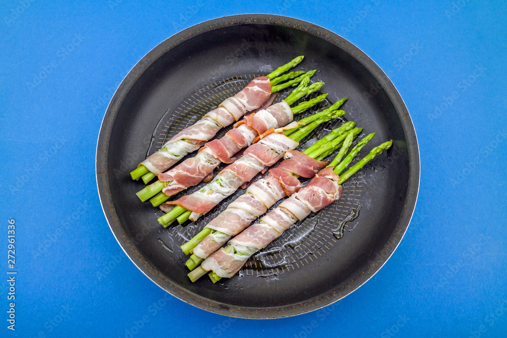 Tasty bacon wrapped asparagus in frying pan