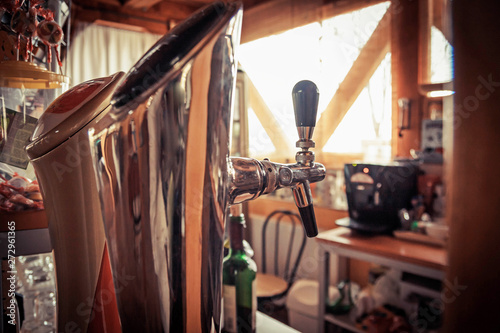 Close up of single tap chrome draft beer kegerator tower at bar or pub