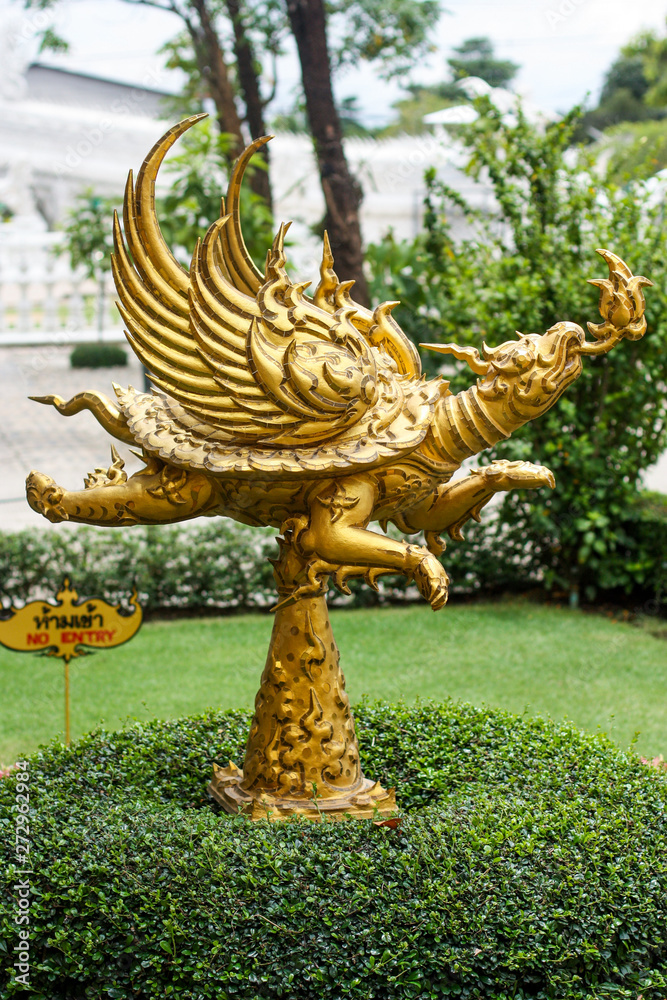 golden dragon statue in garden, Wat Rong Khun in Chiang Rai, Thailand.