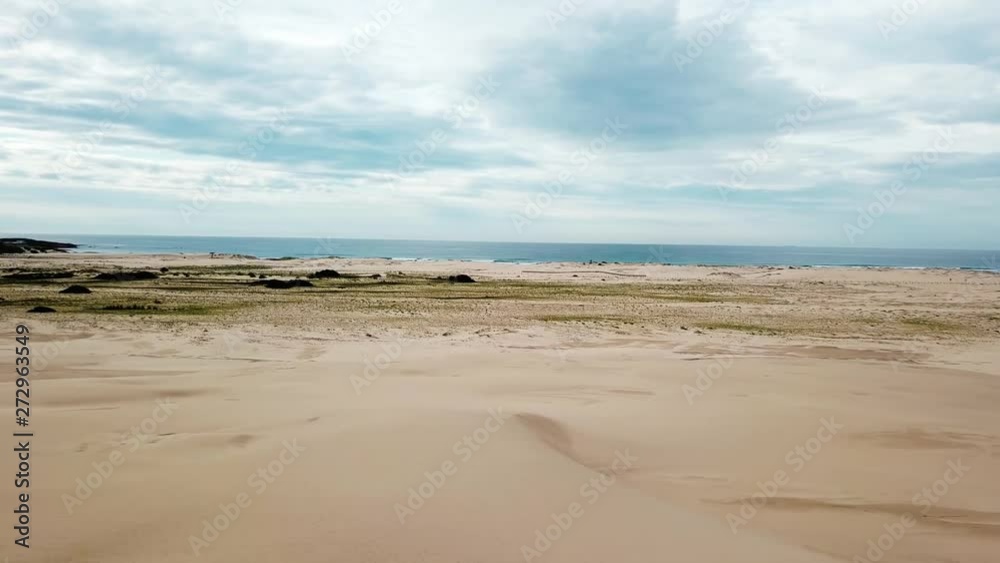 Cinematic Pan Slide Drone Aerial of Male Standing on Top of Sand Dune on Wild Beach And Looking At Sea Near Stockton Australia 4k
