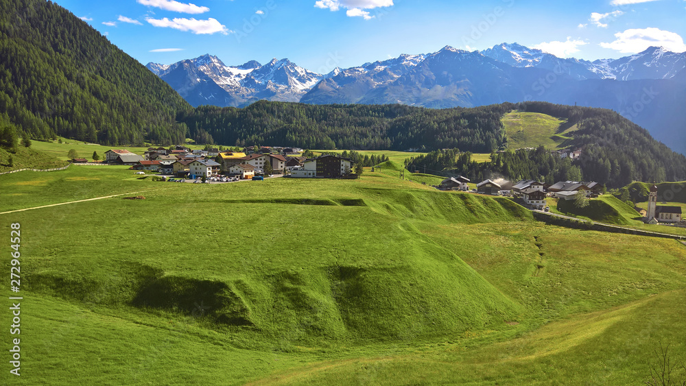 green meadows with a little village and snow covered mountains in austria (Ötztal)