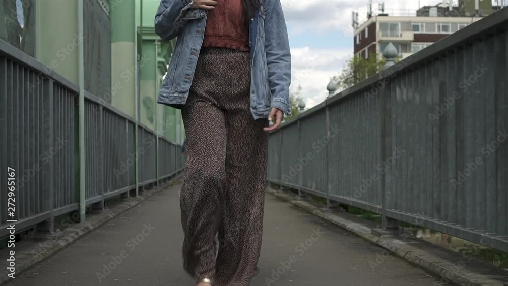 Tilt up of gorgeous hispanic brunette while modeling and walking towards the camera, taking off her denim jacket. Slow motion shot Tilt up of gorgeous hispanic brunette while modeling and walking towards the camera, taking off her denim jacket. Slow motion shot