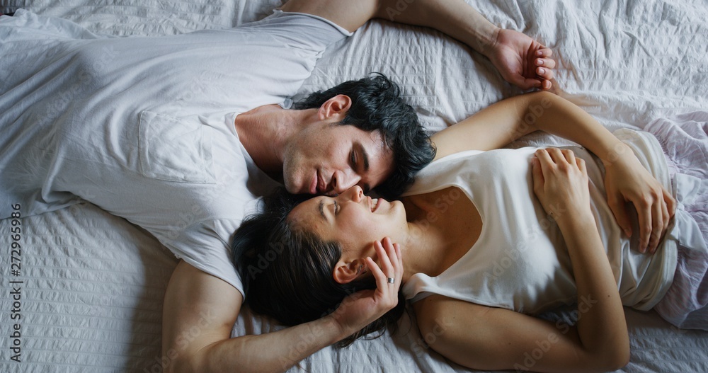 Authentic shot of young couple is relaxing in the bedroom in the early morning in a sunny day.