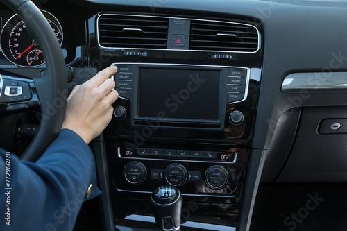Business Frau bedient Autoradio in Mittelkonsole von Mittelklasse-PKW