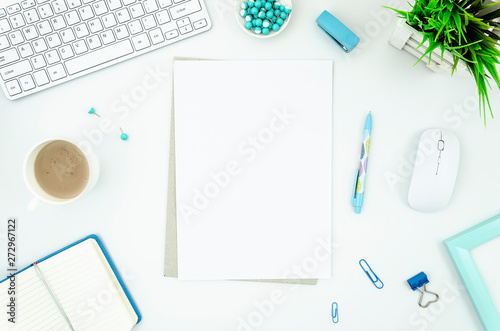 Women's workplace mockup with keyboard and mouse, blue supplies, cup of coffee and blank A4 paper list. Coffee break concept. Top view, flat lay with copy space