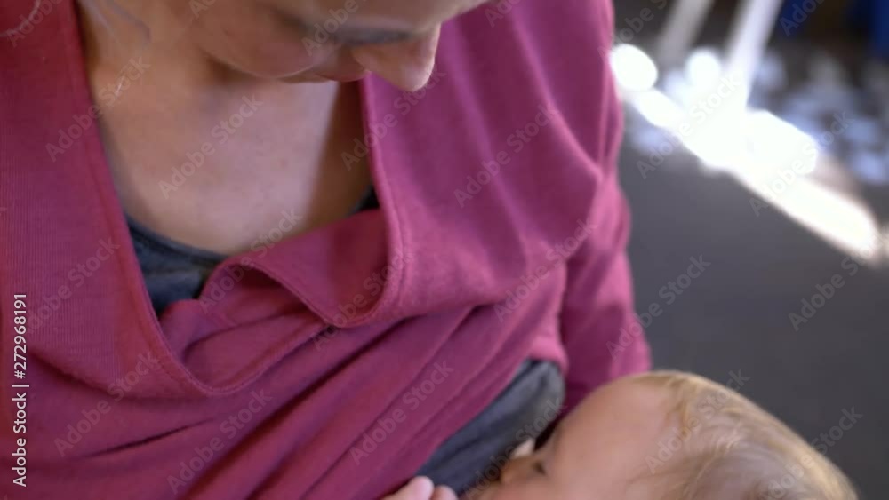 A blonde mother breastfeeding her newborn child A blonde mother breastfeeding her newborn child