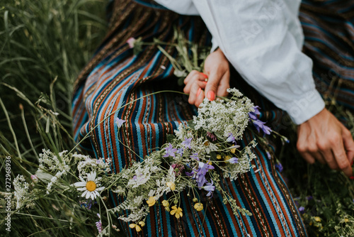 Folk girl in the midsummer making flower