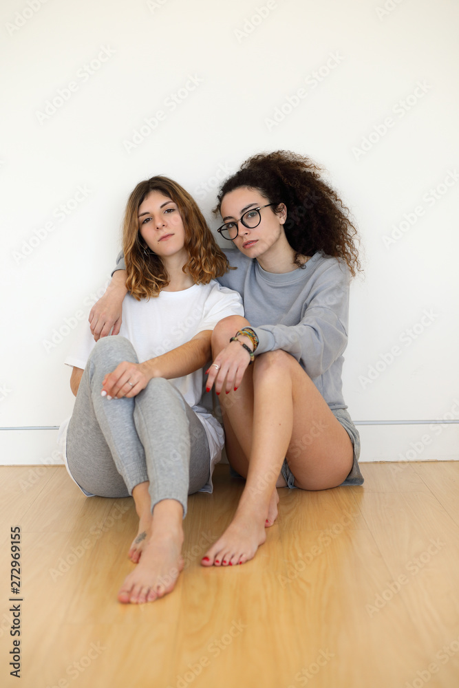 Young lesbian couple portrait. Two casual millennial women at home.