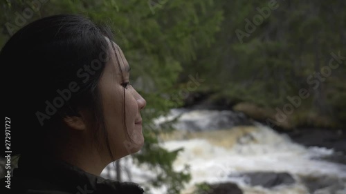 Girl looking at a river in the forest. photo