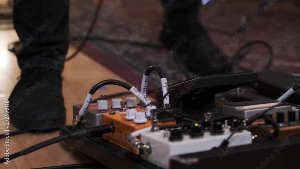 Moving Feet of Guitarist And Electric Guitar Pedals on Floor of Live Room in Professional Recording Studio Moving Feet of Guitarist And Electric Guitar Pedals on Floor of Live Room in Professional Recording Studio