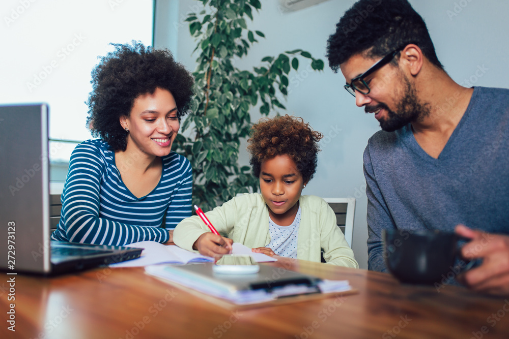 Mother and father helping daughter to do homework learning to calculate Mother and father helping daughter to do homework learning to calculate