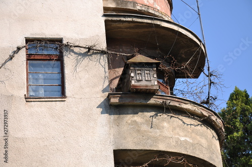 The original birdhouse in the form of a house on the balcony of an old building.