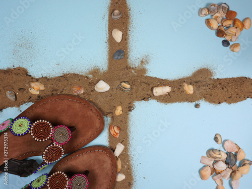 Beach accessoiries with flip flops and shells on blue background for your own text  photo