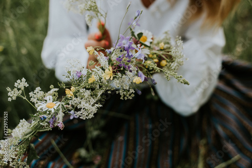 Folk girl in the midsummer making flower