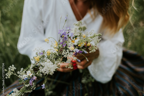 Folk girl in the midsummer making flower