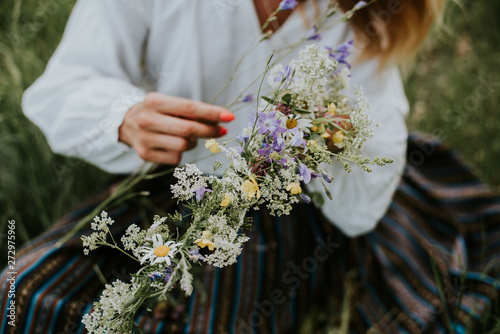 Folk girl in the midsummer making flower