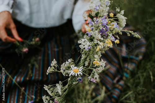 Folk girl in the midsummer making flower