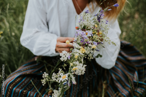 Folk girl in the midsummer making flower