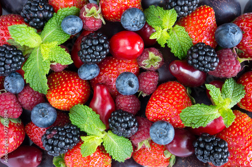 Ripe strawberries, raspberries, blackberry; red berries, plum and bleberries. Top view. Red and blue food. Background berries and fruits. Various fresh summer berries and fruits.