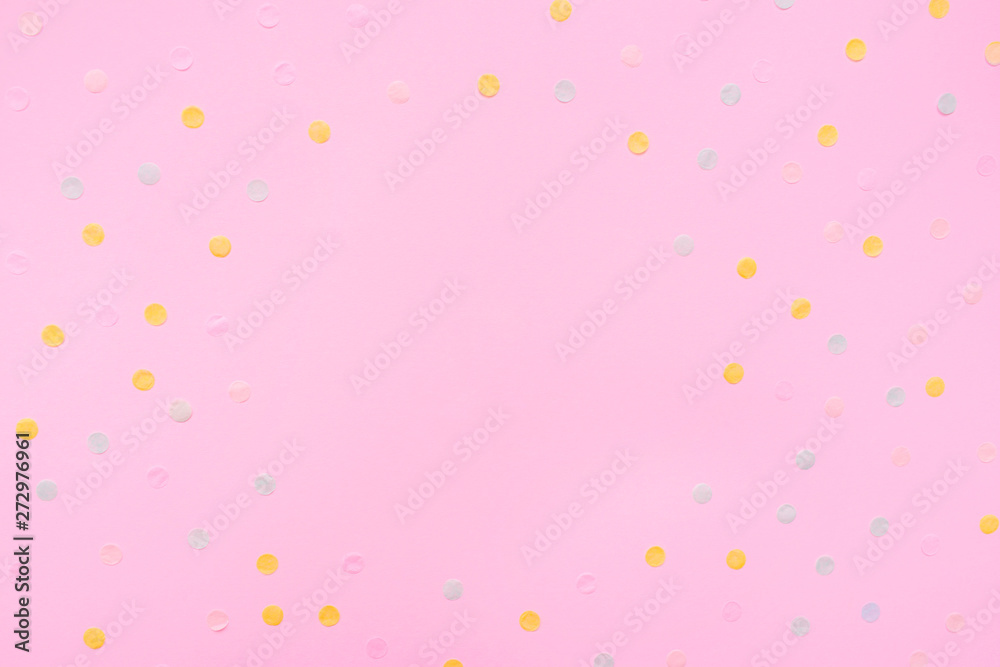 Pink pastel festive background with multicolored confetti. Copy space for your text. Flat lay style. Top view. 