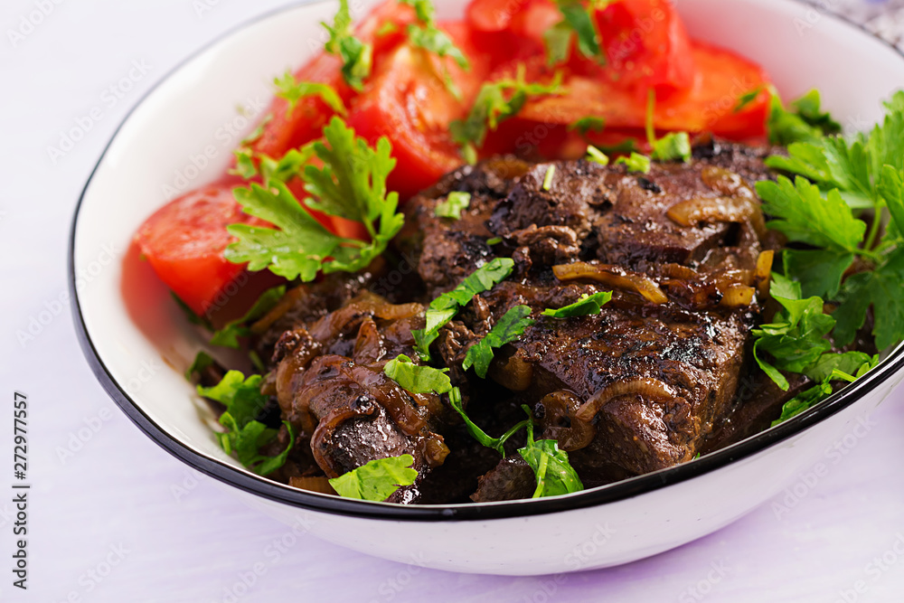 Roasted or grilled beef liver with onion and tomatoes salad. Middle Eastern cuisine.