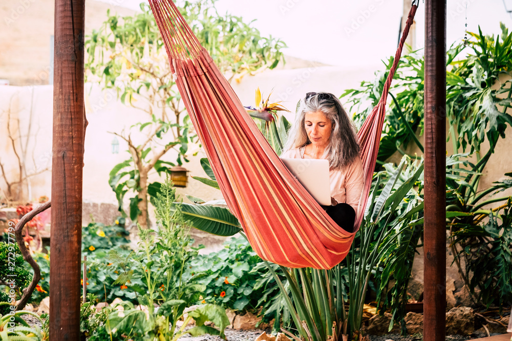 Relax on hammock for alternative people - young woman with long grey white  hair use a laptop computer outdoor in the garden - technology and internet  connection concept Stock Photo | Adobe Stock