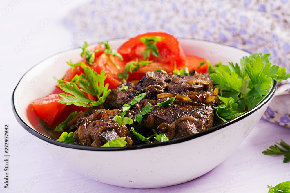 Roasted or grilled beef liver with onion and tomatoes salad. Middle Eastern cuisine.
