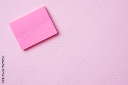 Pink Notepad paper clip and pencil on pink background with copy space. Concept school education, office and freelancing.