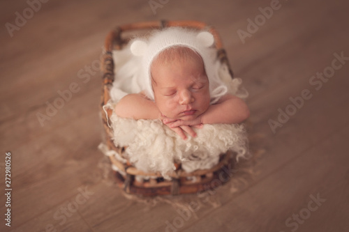 Cute sleeping newborn baby boy in beige color