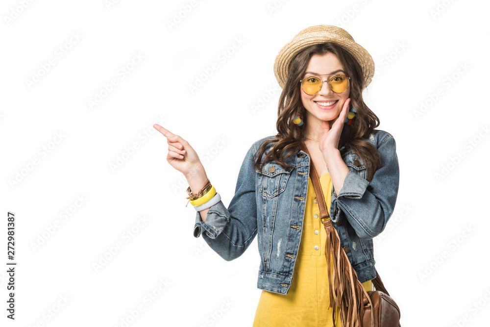 front view of smiling boho girl in denim jacket pointing with finger isolated on white front view of smiling boho girl in denim jacket pointing with finger isolated on white