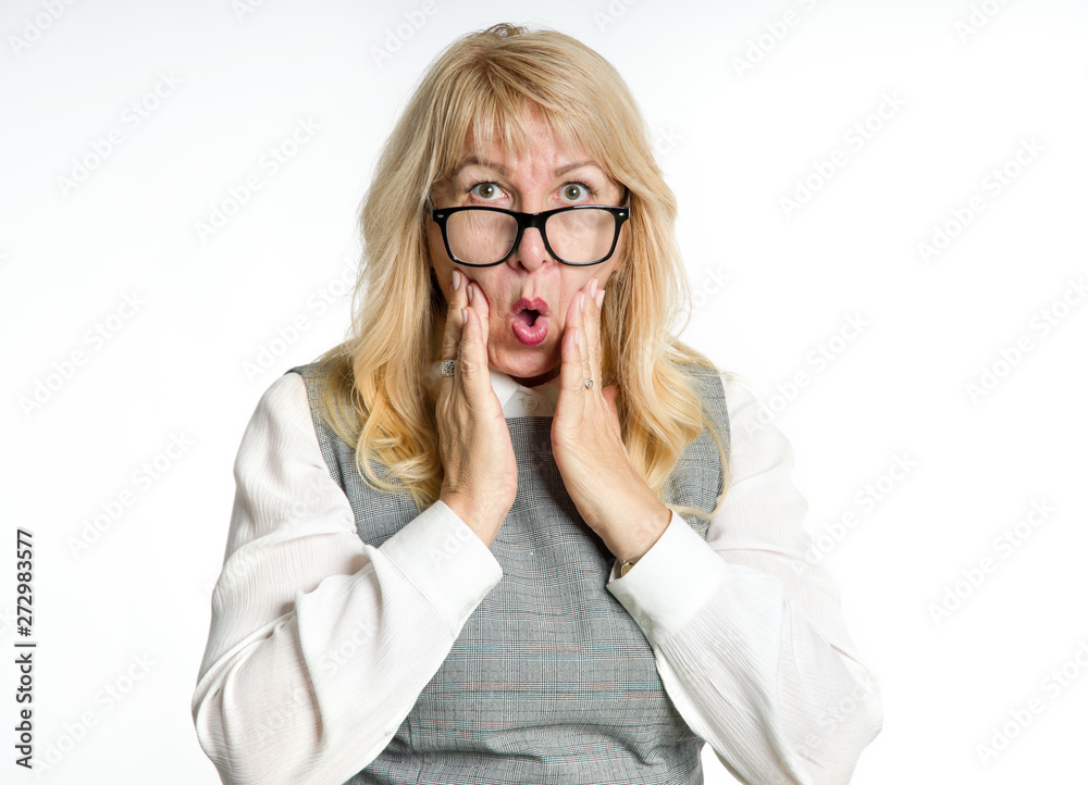 Surprised mature woman in glasses gestures her emotions on a light background. Surprised mature woman in glasses gestures her emotions on a light background.