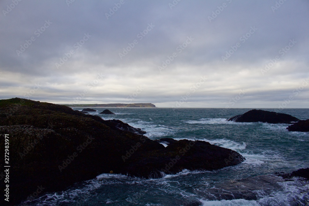 Overlook of ocean from hill above with turbulent seas below, Northern Irish Coast