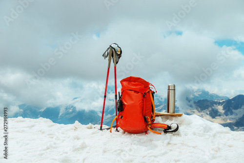  backpack and rekking poles in the snow. winter landscape. mountaineering equipment