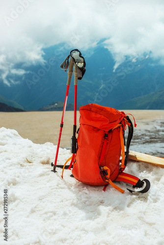  backpack and rekking poles in the snow. winter landscape. mountaineering equipment