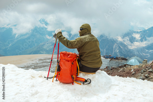 Сlimber reaches the top of mountain peak. Tourist climbs mount Elbrus, winter landscape