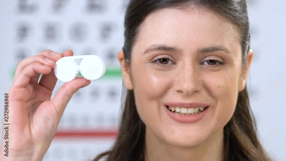 Smiling woman taking off eyeglasses and showing lens at camera, recommendation Smiling woman taking off eyeglasses and showing lens at camera, recommendation